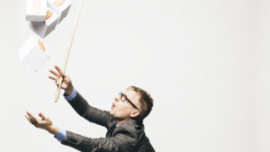Hans Rosling fångar vita lådor med orange gubbar på som faller uppifrån